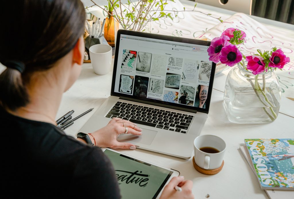 Woman graphic designer searching ideas online on laptop