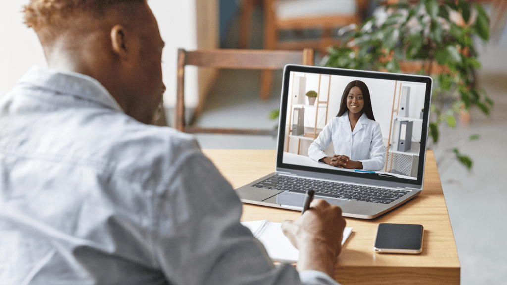 person taking notes - laptop with virtual meeting 