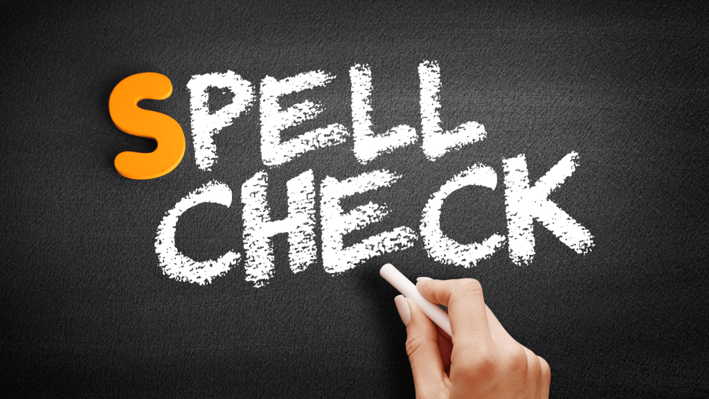 hand holding chalk writing spell check