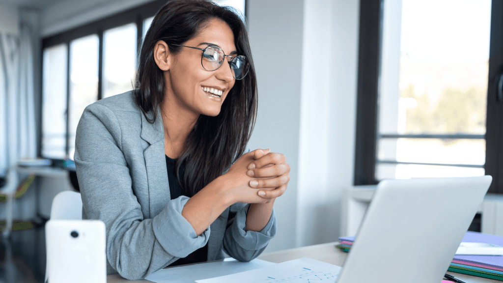 woman smiling and looking at laptop