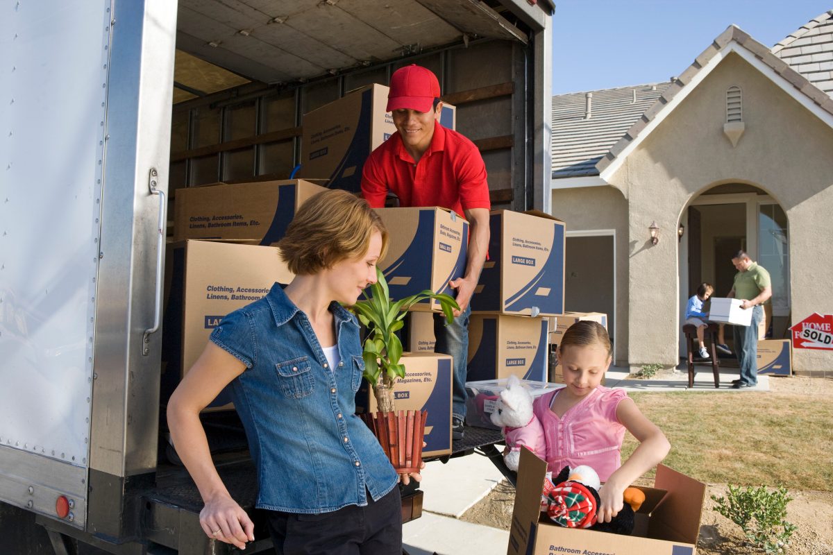 AdobeStock_129855783 Family and worker unloading truck of cardboard boxes