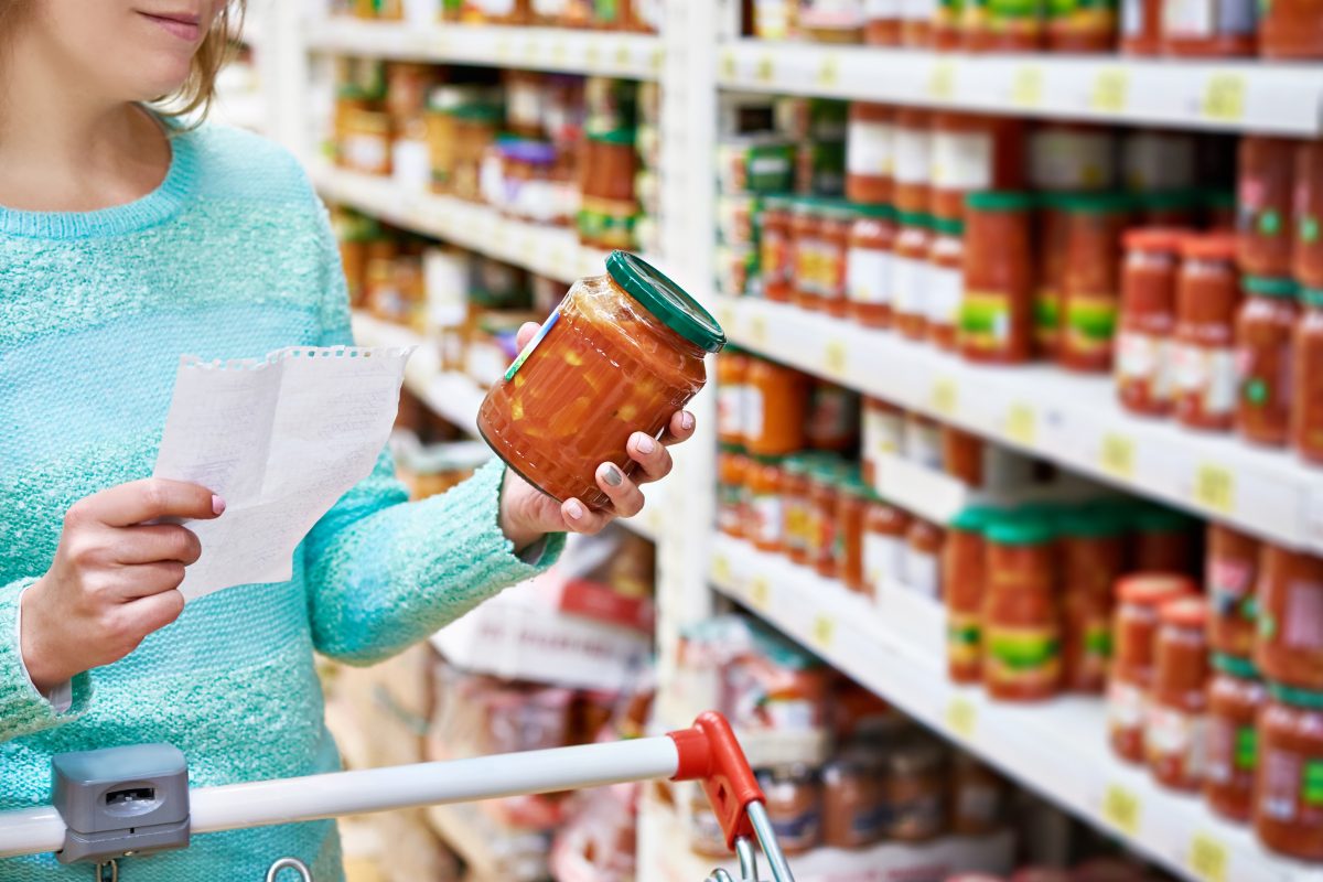 Woman chooses lecho tomato at the grocery store