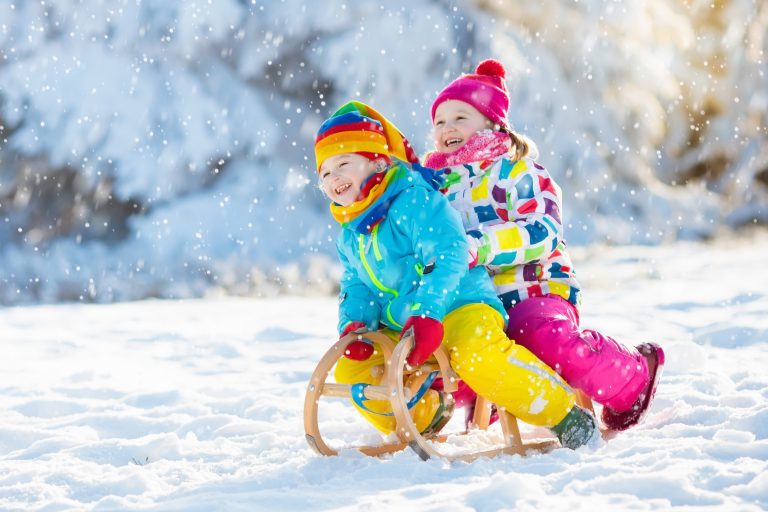 Kids play in snow. Winter sleigh ride for children