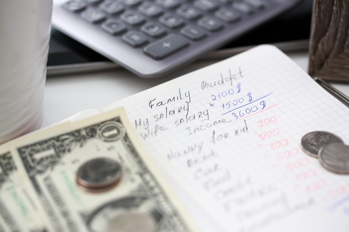 Notepad page with handwritten calculation of family budget closeup