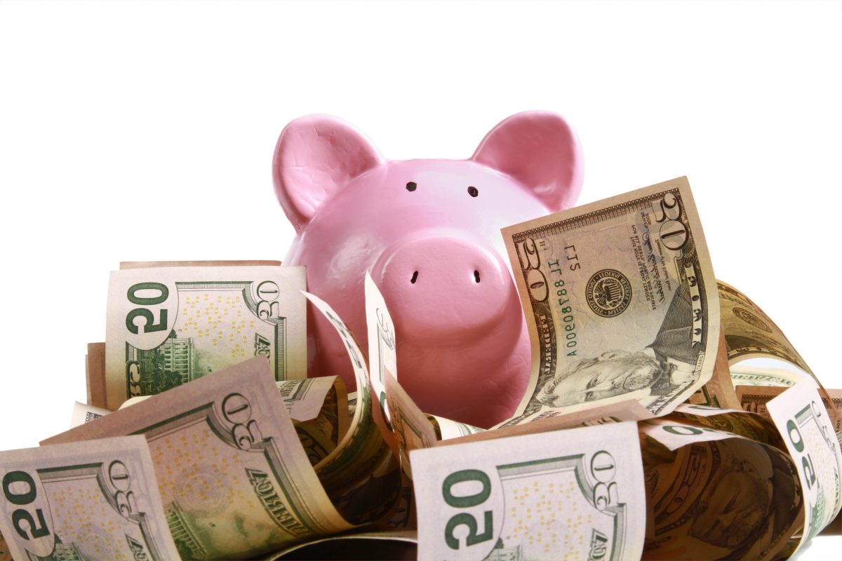 piggy bank standing on dollars piggy bank standing on dollars at the desk
