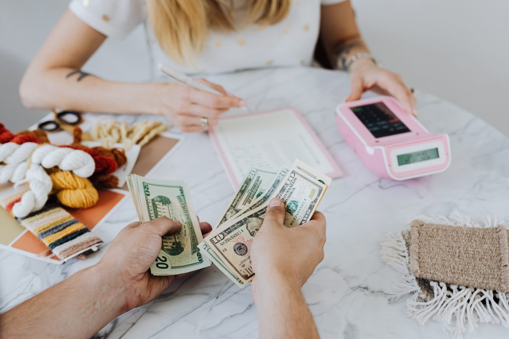 family sitting down calculating debt and hands showing money being split for debt