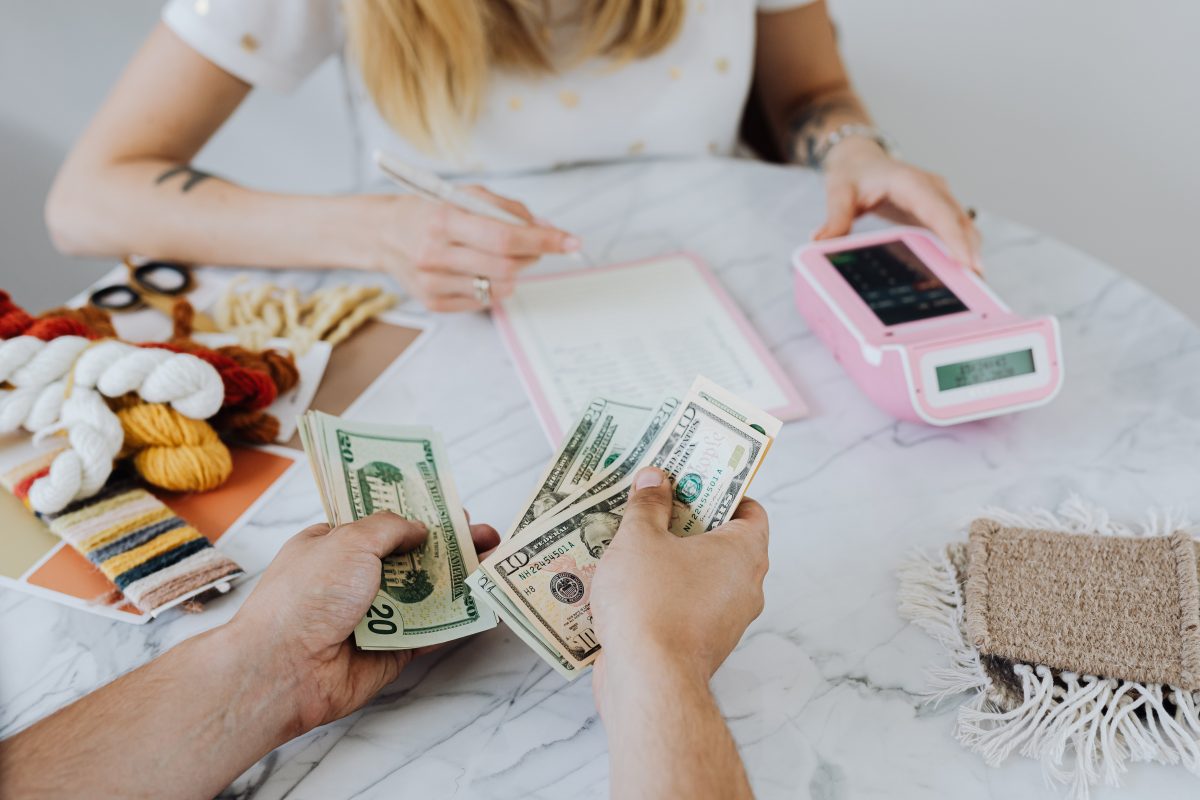 family sitting down calculating debt and hands showing money being split for debt