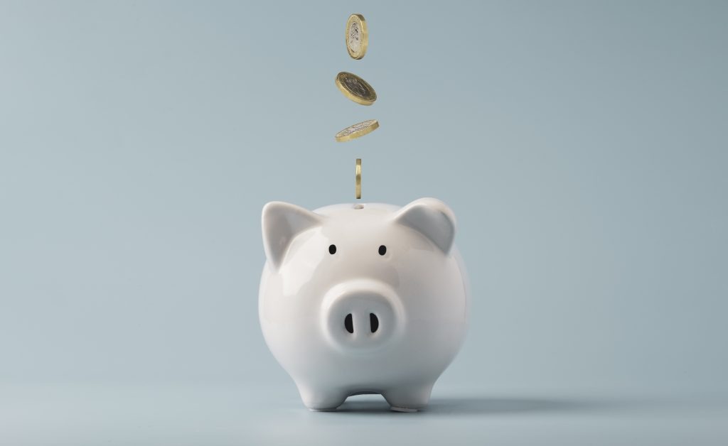 Coins falling to white piggy saving , Financial and money deposit concept.