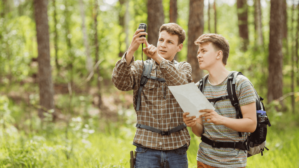 2 guys looking at electronic device while holding paper