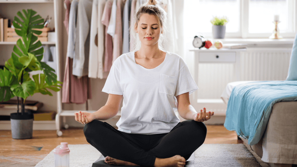 Woman meditating in bedroom