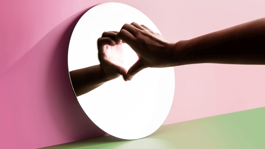 hand on mirror to show heart shape - self-love affirmations