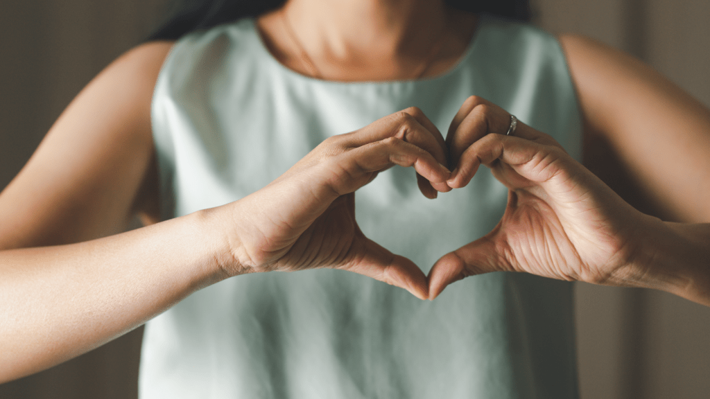 Woman shaping a heart with her hands - The Power of Self Discovery